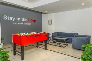 a red foosball table in a room with a couch at Loop by Zolo Baani Square, Gurugram in Gurgaon