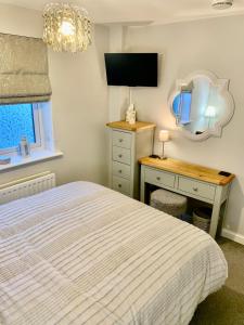 a bedroom with a bed and a desk and a mirror at The Coach House, Cleobury Mortimer in Cleobury Mortimer