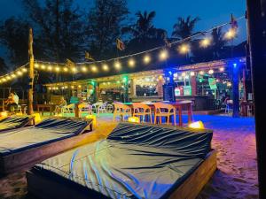 a patio with tables and chairs and lights at night at Beach Lovers Tiny House in Nilaveli