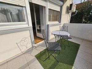 a patio with two chairs and a table on a balcony at Airport Apartment in Surčin +7 photos