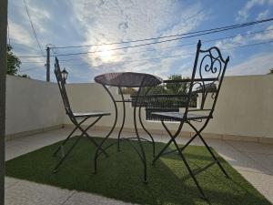 a wrought iron table and two chairs on a patio at Airport Apartment in Surčin
