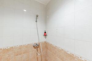a shower with a hose in a bathroom at RedDoorz Plus at Buah Batu in Bandung +22 photos