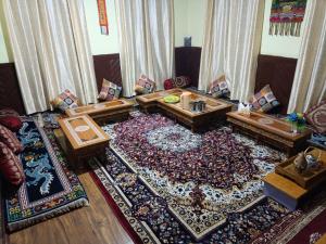 a living room filled with tables and a rug at Valley View Homestay Lahaul in Gondla