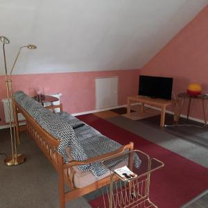 a room with a bed and a flat screen tv at Farbenfrohe Dachgeschoßwohnung in Giesen