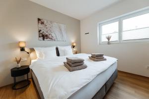 a bedroom with a large white bed with towels on it at Ferienhaus HeimatLay in Mörsdorf