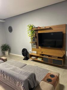 a living room with a large flat screen tv at Búzios Family House in Búzios