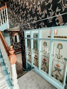 a staircase with a blue glass cabinet with wine glasses at The Seadoor, Shetland Islands in Lerwick