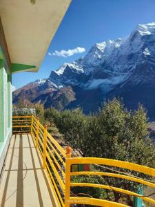 a yellow balcony with a view of a mountain at Valley View Homestay Lahaul in Gondla