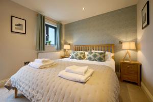 a bedroom with a large bed with towels on it at Riverside Park 3 in Keswick