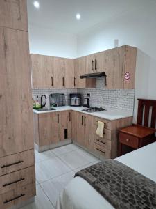 a kitchen with wooden cabinets and a counter top at Unit 17 Sunbird Self-Catering in Richards Bay +6 photos