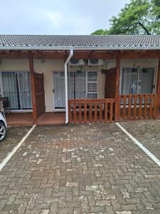 a house with a wooden porch and a patio at Unit 17 Sunbird Self-Catering in Richards Bay