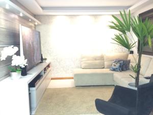 sala de estar con sofá y TV en Apartamento de Luxo em Torres, en Torres