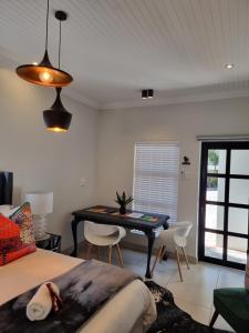 a bedroom with a desk and a bed and a table at Picasso Dreams in Kimberley