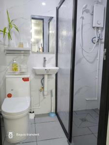 a bathroom with a toilet and a sink at Secret Room Bliss in Baguio