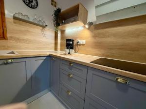 a kitchen with blue cabinets and a sink at NIVAS Apartment Pefkochori in Pefkochori +27 photos