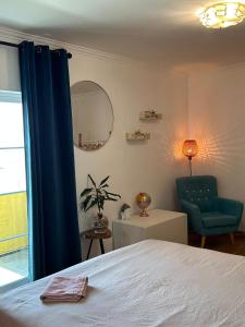 a bedroom with a bed and a blue chair at The Throne in Alcabideche