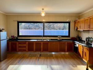 a large kitchen with a large window in it at Sunny Sunset House in Ponta do Pargo +10 photos
