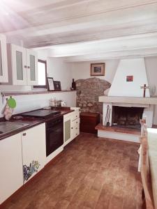 a kitchen with a stove and a fireplace at Villa La Pineta in Umbertide