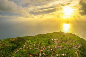 an island in the ocean with the sun in the sky at Sunny Sunset House in Ponta do Pargo