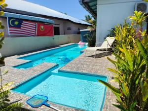 a swimming pool with an american flag next to a house at Sri impiana in Pantai Cenang
