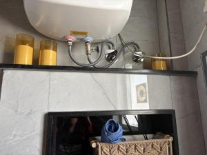 a bathroom with a sink and a toilet and yellow candles at B&A Stays in Dehradun