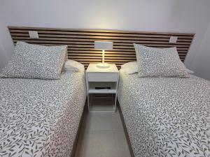 a bedroom with two beds and a lamp on a night stand at Estrella y mar in La Estrella