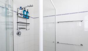 a bathroom with a shower with two bottles on the wall at Fireplace & Winter Swells, 800m to the beach in Ocean Grove +22 photos