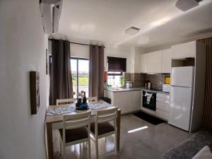 a kitchen with a table and chairs and a refrigerator at RJ Summer in Sagres
