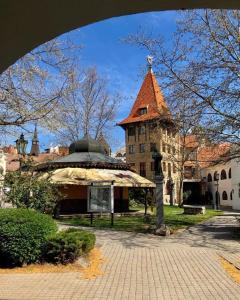 a large building with a clock tower in front of it at Apartmán Thea in Komárno