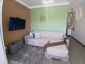 a living room with a couch and a flat screen tv at RJ Summer in Sagres