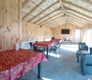 a dining room with tables and chairs in a wooden building at Casa NICORAD Camere in Pucioasa