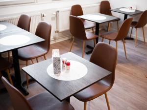a row of tables and chairs in a restaurant at Hotel Aveny in Gävle