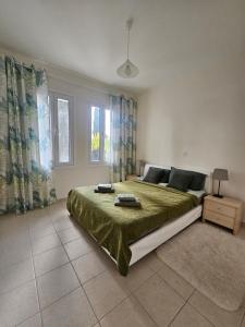 a bedroom with a large bed with a green blanket at Quiet 61 Perivolia in Meneou