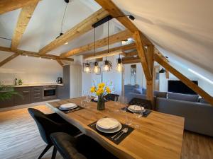 a dining room with a large wooden table with chairs at Modernes 3-Familienhaus im Allgäu in Erkheim