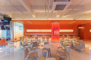 a cafeteria with tables and chairs in a room at SilMiCore Hostel in Shanghai