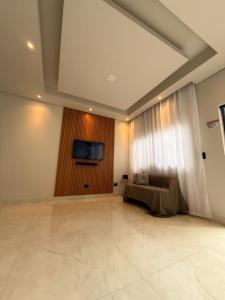 a living room with a couch and a tv on a wall at Espaço prime piscina aquecida in Sorocaba