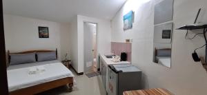 a small room with a bed and a sink at Casa Oeste in Moalboal