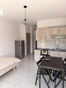 a kitchen with a table and chairs in a room at Vana's Apartments in Sarandë