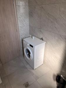 a white washing machine sitting in a bathroom at Vana's Apartments in Sarandë