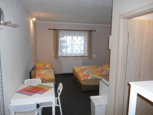 a small room with two beds and a table at Penzion Gerhard Klíny in Klíny