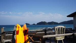 a view of the ocean from a deck with a table and chairs at Pavilion Beachfront in Shishikui