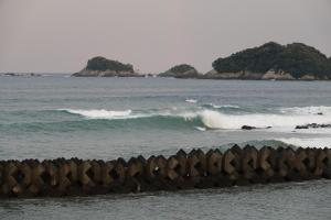 a wave in the ocean with islands in the distance at Pavilion Beachfront in Shishikui +48 photos