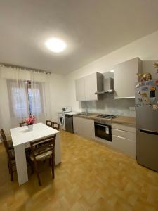 a kitchen with a white table and a white refrigerator at Casa il Giardino in Castiglion Fiorentino