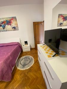 a bedroom with a bed and a desk with a television at Casa il Giardino in Castiglion Fiorentino
