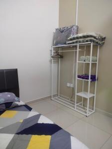 a room with a bed and a shelf with towels at Stingless Bee Homestay in Kluang +1 photo