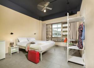 a bedroom with a bed with a red suitcase at Abraham Tel Aviv in Tel Aviv