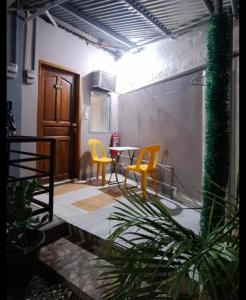 a room with a table and two yellow chairs at Casa Oeste in Moalboal
