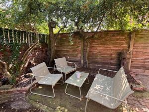 three chairs and a table in front of a fence at Stylish Didsbury House in Manchester
