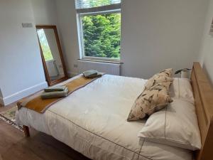 a bedroom with a large bed with a large window at Stylish Didsbury House in Manchester