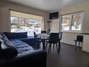 a living room with a couch and a table with chairs at Gardenvillage house in Daržininkai